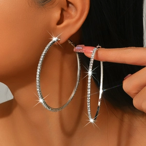 Detail shot of large silver hoop earrings with shimmering rhinestones for parties