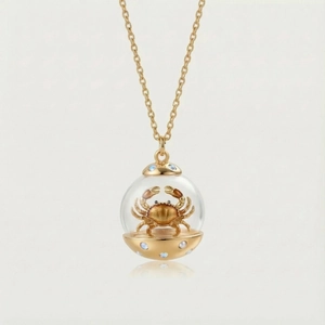 Vue détaillée du pendentif zodiaque doré avec un crabe miniature pour le signe Cancer