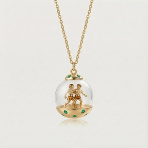 Détail du pendentif sphère Gémeaux avec pierres vertes sur une chaîne dorée fine