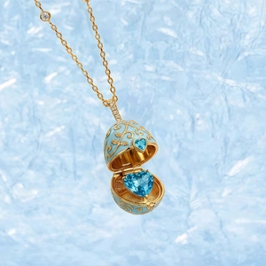 Makro-Detail eines öffenbaren blauen Emaille-Ei-Anhängers im Fabergé-Stil mit blauen Herzsteinen