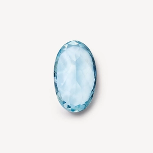Macro shot of oval cut light blue topaz gemstone with high clarity and faceted edges