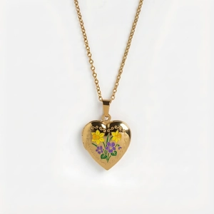 Detailansicht eines Herz-Medaillons mit Emaille-Blumenmuster an Goldkette