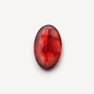 Macro detail of oval faceted red garnet gemstone with 18k gold vintage locket