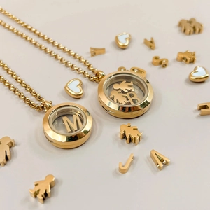 Macro view of 18k gold DIY locket necklace with transparent shell and letter charms