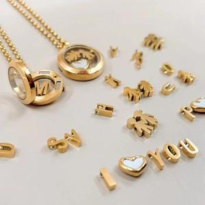 Macro view of gold round floating locket pendant with DIY letters and heart charms