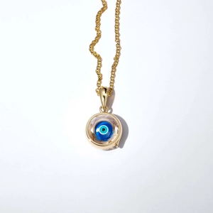 Vue détaillée du pendentif médaillon oeil bleu plaqué or avec cristal central bleu