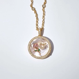 Vue détaillée du médaillon vintage doré avec rose rose et cœur à l'intérieur du pendentif