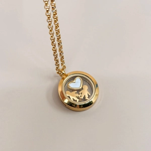 Detail of 18K gold hollow glass locket pendant with heart and small person charms