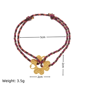 Multilayer bohemian woven bracelet with a vintage gold floral pendant on white background