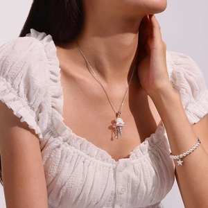 Dettaglio della collana con cono gelato e bracciale di perle con stella su modella
