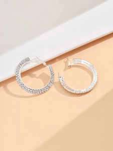 Detail of silver rhinestone hoop earrings with double row crystals on a stone display