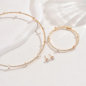 Detail view of gold-plated jewelry set with shimmering crystals and teardrop zirconias