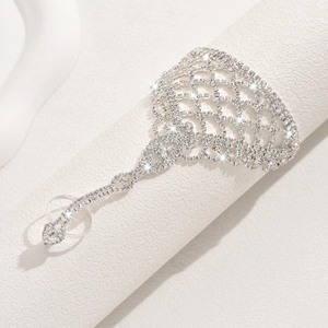 Detalle de la pulsera de mano con malla plateada y pedrería en soporte blanco