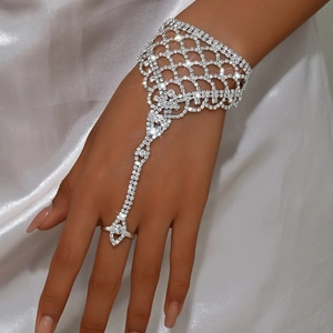 Detalle de pulsera de mano de malla con diamantes de imitación y anillo conectado