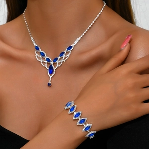 Close-up of bridal jewelry set with blue pear-cut gems and sparkling rhinestones on model