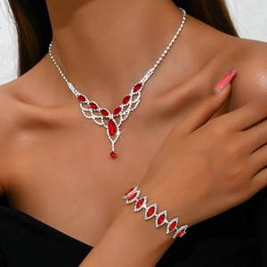 Detailed view of silver necklace and bracelet set with red marquise gems on model