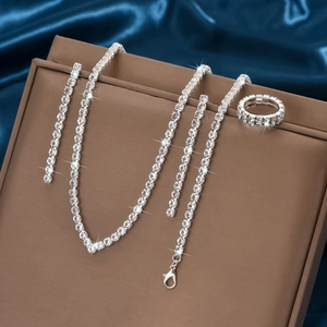Parure de bijoux géométriques avec strass et bague sur satin bleu pour la mariée