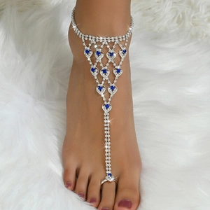 Cavigliera in argento con cristalli blu a cuore su sfondo di pelliccia sintetica bianca