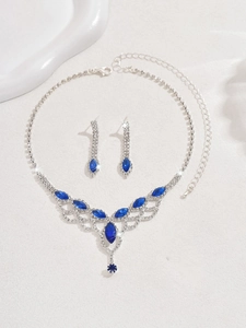 Macro detail of tear-drop crystal jewelry set with navy blue stones and silver plating
