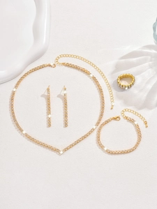 Vue détaillée à plat d'une parure de bijoux de mariée quatre pièces en or avec strass