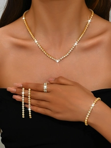 Détail d'un ensemble de bijoux avec collier en V, boucles d'oreilles et bague éclatante