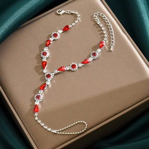 Détail d'une chaîne de main bohème en cristal rouge avec motif floral sur satin élégant