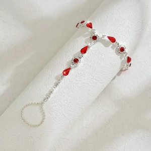 Vue macro du bracelet de main argenté avec des pierres rouges en forme de goutte d'eau