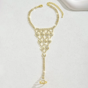 Dettaglio del bracciale anello a cuore dorato con strass brillanti su pietra bianca