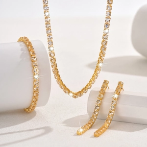 Détail d'un ensemble de bijoux tennis dorés avec des cristaux étincelants à coupe carrée