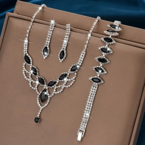 Detail of silver drop necklace set with black gems on blue satin and brown leather