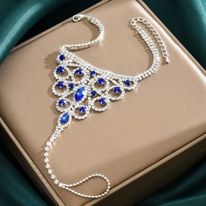 Detailed macro view of silver slave bracelet with deep blue rhinestones on silk
