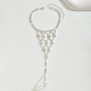 Dettaglio di un bracciale da mano con cuori di strass scintillanti su fondo di pietra