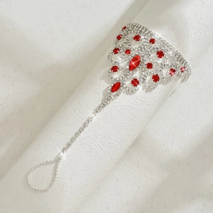 Macro detail of silver finger bracelet featuring red marquise stones and white rhinestones