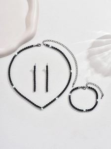 Vue détaillée d'une parure en strass noirs avec collier, bracelet et boucles d'oreilles