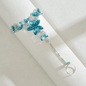 Close-up of silver slave bracelet featuring blue crystal flowers and micro-set rhinestones