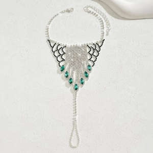Detailed view of silver foot jewelry with emerald rhinestones and sparkling crystal fringe