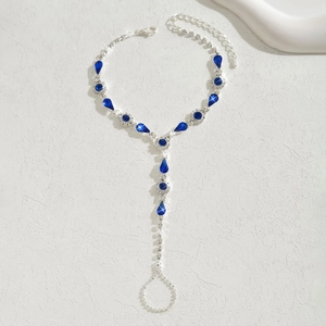 Détail de la chaîne de main argentée avec cristaux bleus et strass style bohème