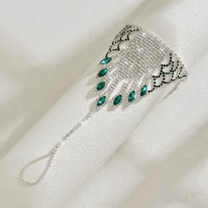 Detail of silver toe ring anklet with green rhinestones and tassel wing design