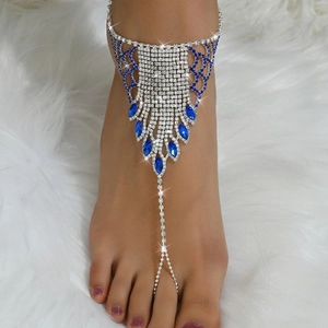 Detailed macro of silver slave anklet with blue teardrop stones on white fur