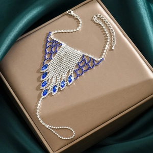 Macro view of bridal rhinestone foot chain with blue marquise stones and silver tassels
