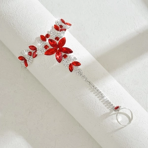 Detailed close-up of a red flower crystal finger ring bracelet with silver leaf patterns