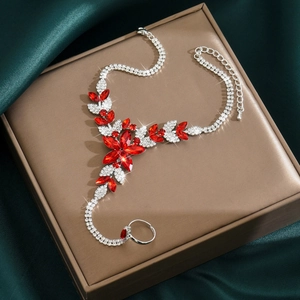 Detail of silver slave bracelet with red marquise gems and rhinestones on green silk