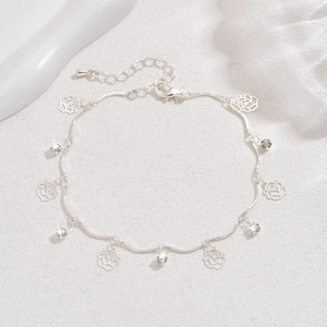 Détail d'une chevillère argentée avec pendentif rose, strass et fermoir ajustable