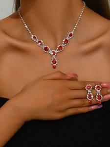 Close-up of bridal jewelry set with red gemstones and silver plating on model