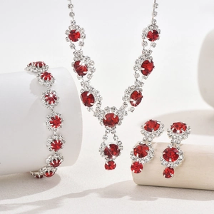 Detailed view of bridal jewelry set with faceted red rhinestones and silver alloy plating