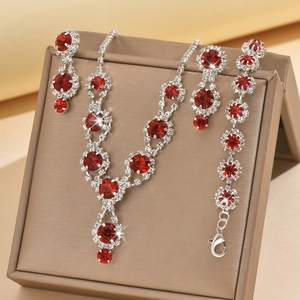Close-up of silver bridal jewelry set with deep red ruby-style crystals and sparkling rhinestones