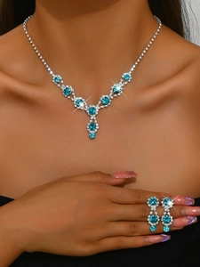 Close-up of silver bridal jewelry set with sky blue crystals on elegant female model