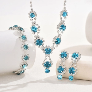 Detail of bridal jewelry set with blue sunflower crystal necklace, bracelet and earrings
