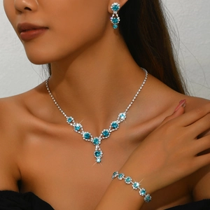 Detail of silver bridal jewelry set with cyan rhinestones including necklace and earrings