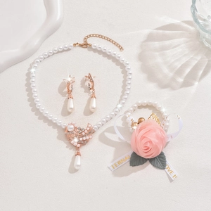 Detailed set of pearl necklace and bird earrings with elegant pink rose wrist corsage